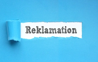 Reklamationsmanagement: Schriftzug "Reklamation" unter abgezogener blauer Tapete