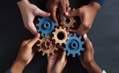 standard work Hände greifen ineinandergreifende Zahnräder – Symbol für Standard Work